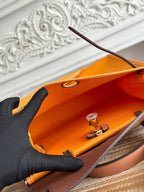 アプリコットオレンジのキャンバスとブロンズブラウンのカーフスキンを使用したジップキャビン31バッグ