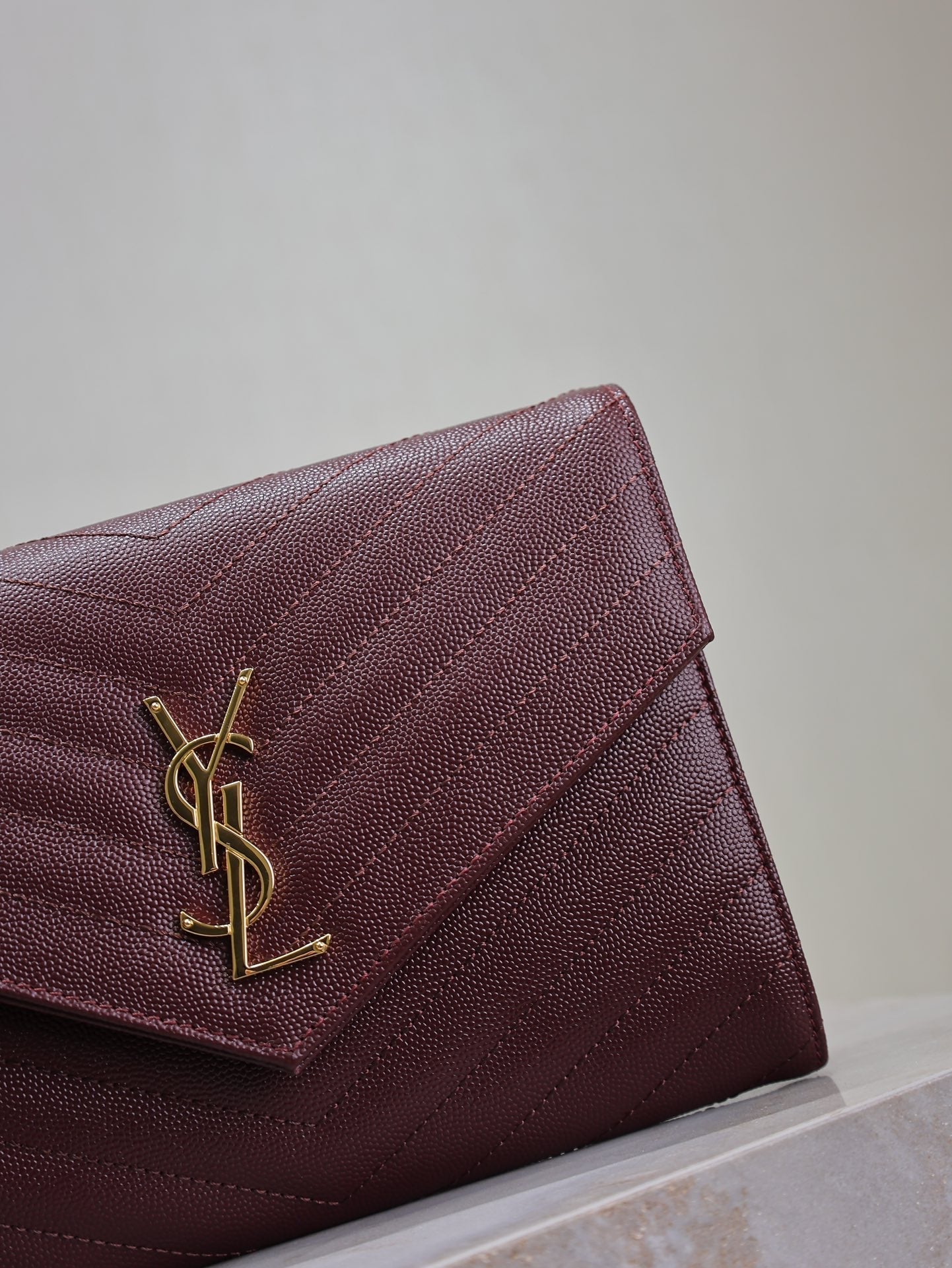 CASSANDRE CLUTCH 21 IN BORDEAUX RED LAMBSKIN GOLD HARDWARE